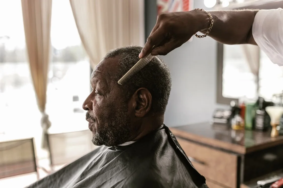 Barber combing a client's hair during a haircut